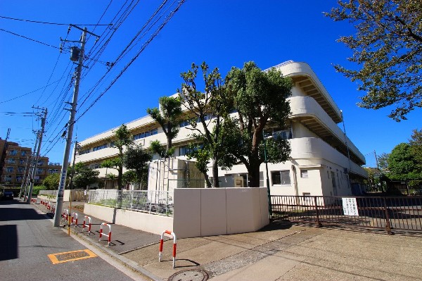 西寺尾小学校(線路沿いに建つ、各学年2クラス程の小学校。教育目標は「進んで学び　学びを深め　学びを活かす子ども」)