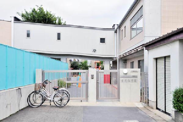 愛光保育園(駅から続く道の途中に広い緑の空間を提供する園庭では、定員150名の園児が自由遊びに興じている。木とコンクリートでできたきれいな園舎は、数年前に改築されたものです。)