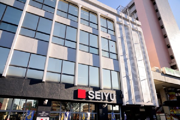 西友小平店(4階建ての店舗では、生鮮食料品をはじめ、お惣菜、薬、化粧品、日用雑貨、衣類など多彩な商品が販売されています。)